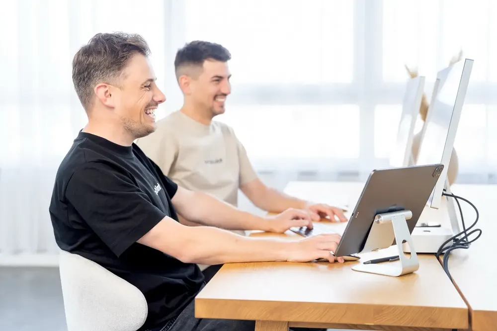 Zwei Teammitglieder arbeiten nebeneinander am Schreibtisch