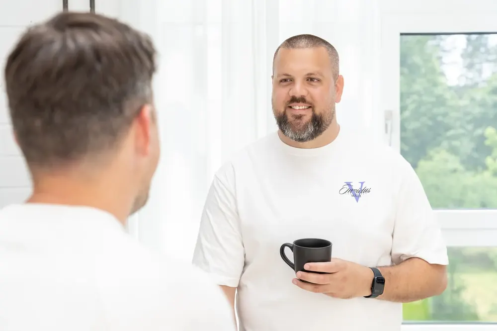 Zwei Teammitglieder im Gespräch bei einer Tasse Kaffee