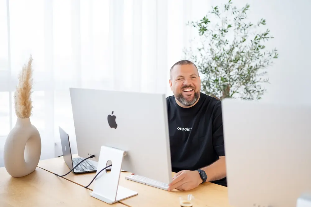 Teammitglied am Schreibtisch vor einem iMac